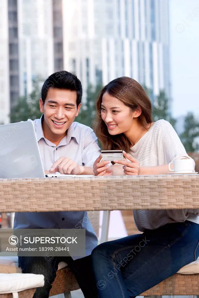 Couple Online Shopping at a Cafe