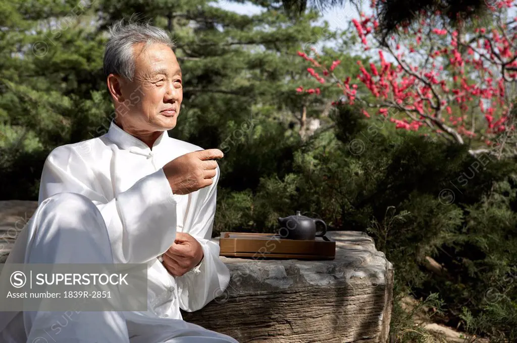 Portrait Of Elderly Man Drinking From Small Cup