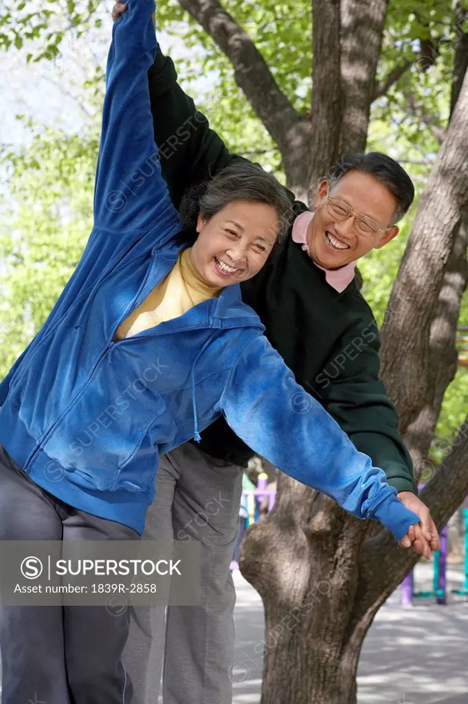 Senior Citizens Stretching Their Arms In Park