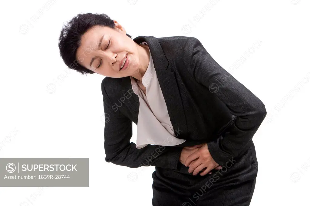 Middle_aged businesswoman suffering from stomachache