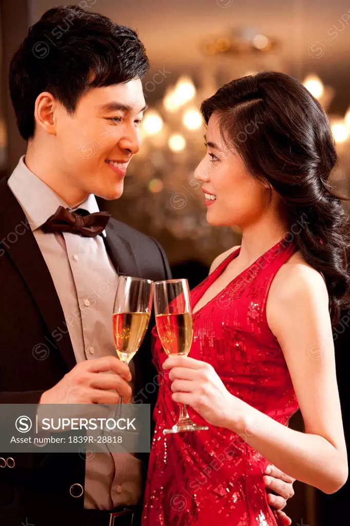 Young couple having champagne in a luxurious room