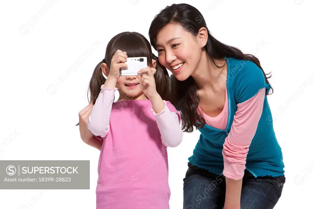 Happy mother and daughter holding a camera