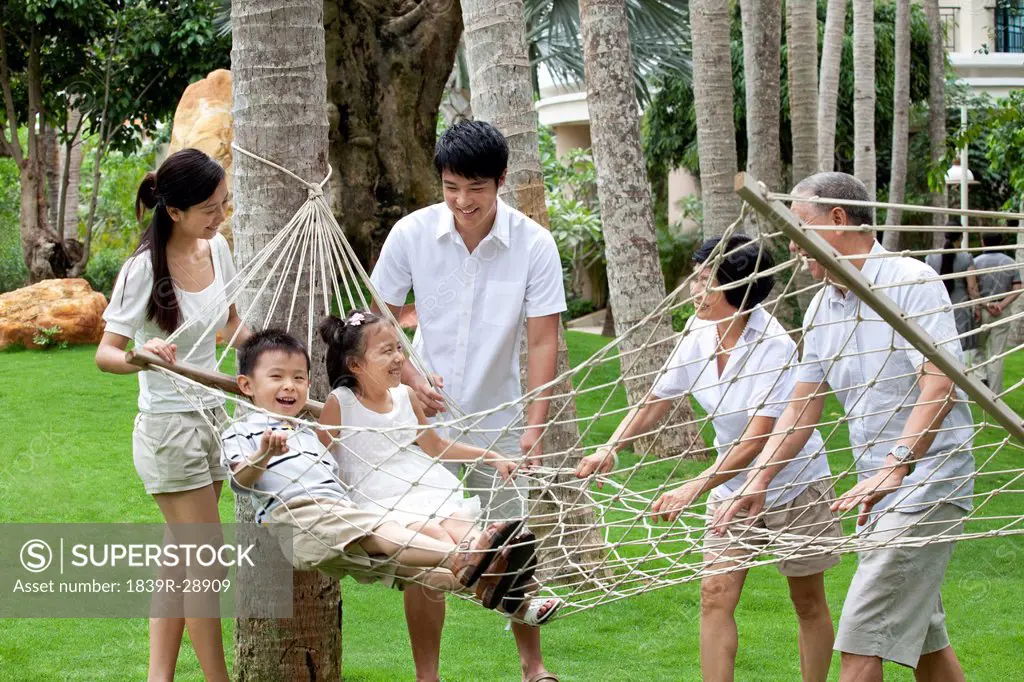 Portrait of a happy family playing on a hammock