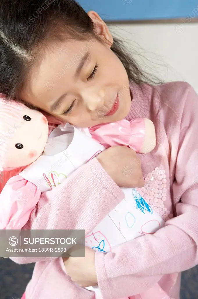 Girl Hugging Doll With Eyes Closed