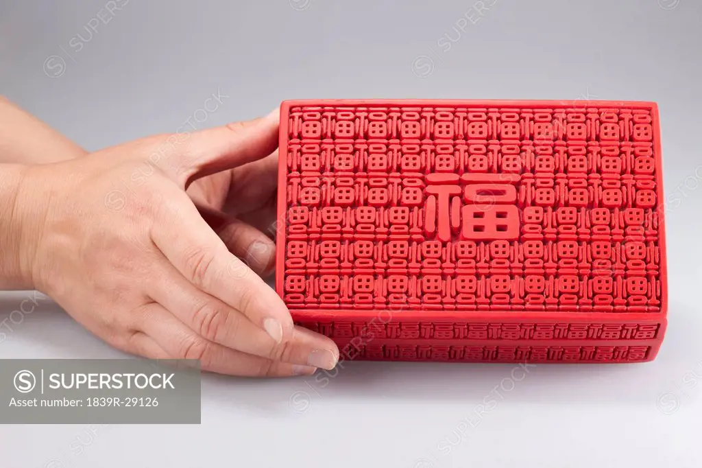 Hand holding traditional Chinese box