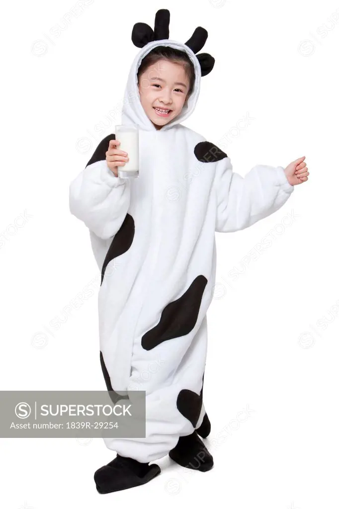 Cute girl in a cow costume with a glass of milk
