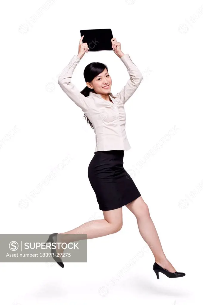 Businesswoman Jumping While Holding Digital Tablet