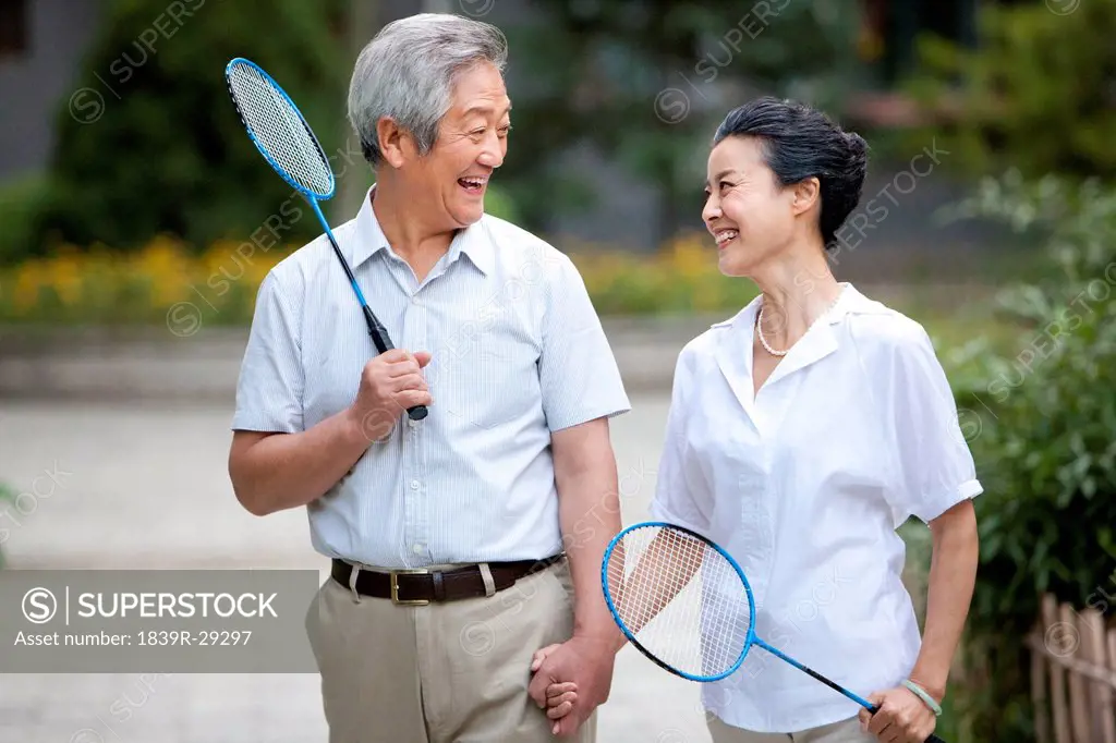 Senior couple holding badminton racket