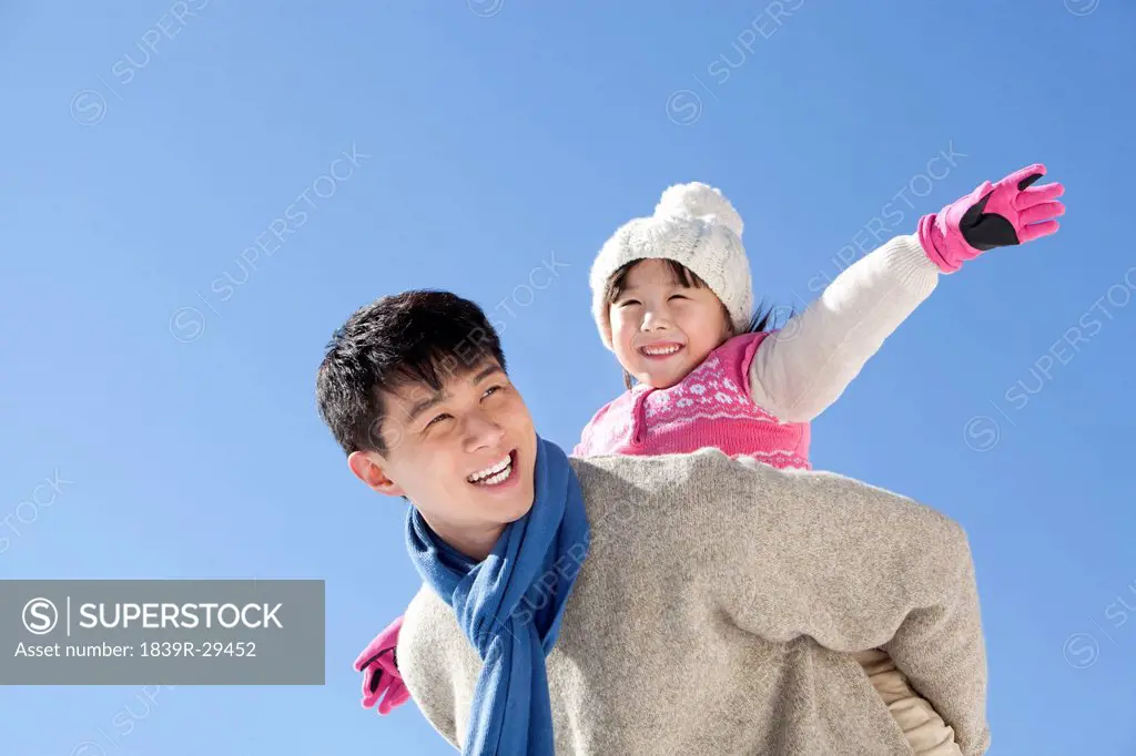 Father playing with daughter in winter time
