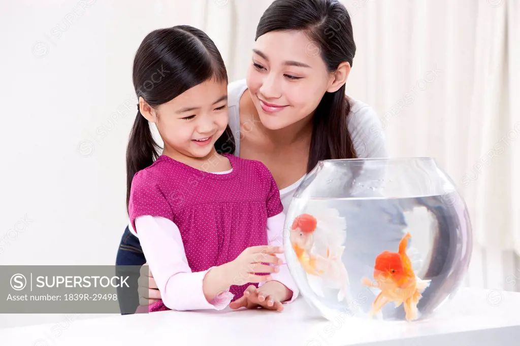 Mother and daughter with goldfish