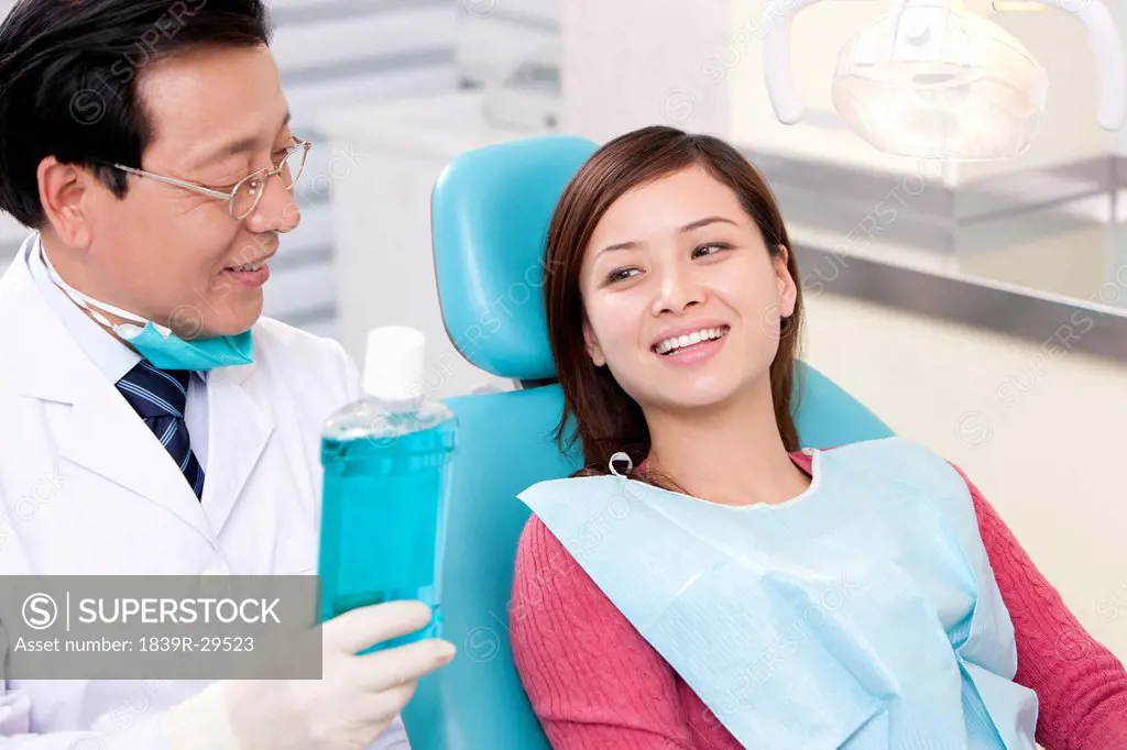 Dentist introducing mouth wash to patient