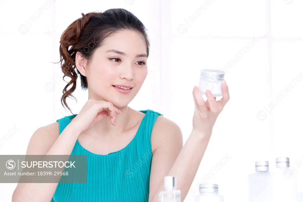 Beautiful young woman with skincare products