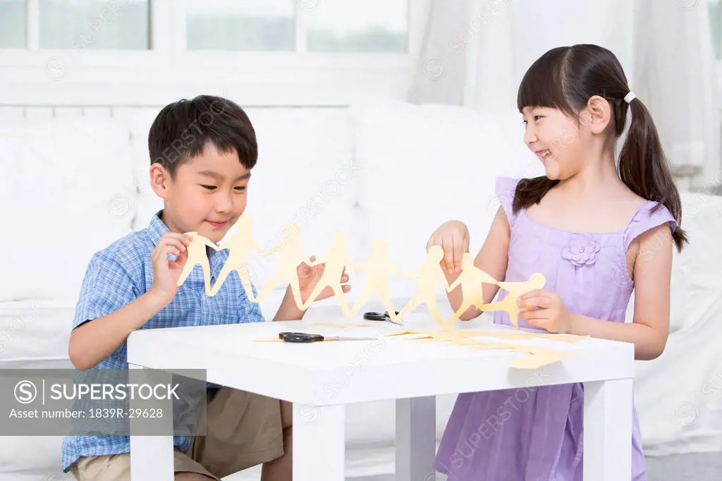 Boy and girl making papercut