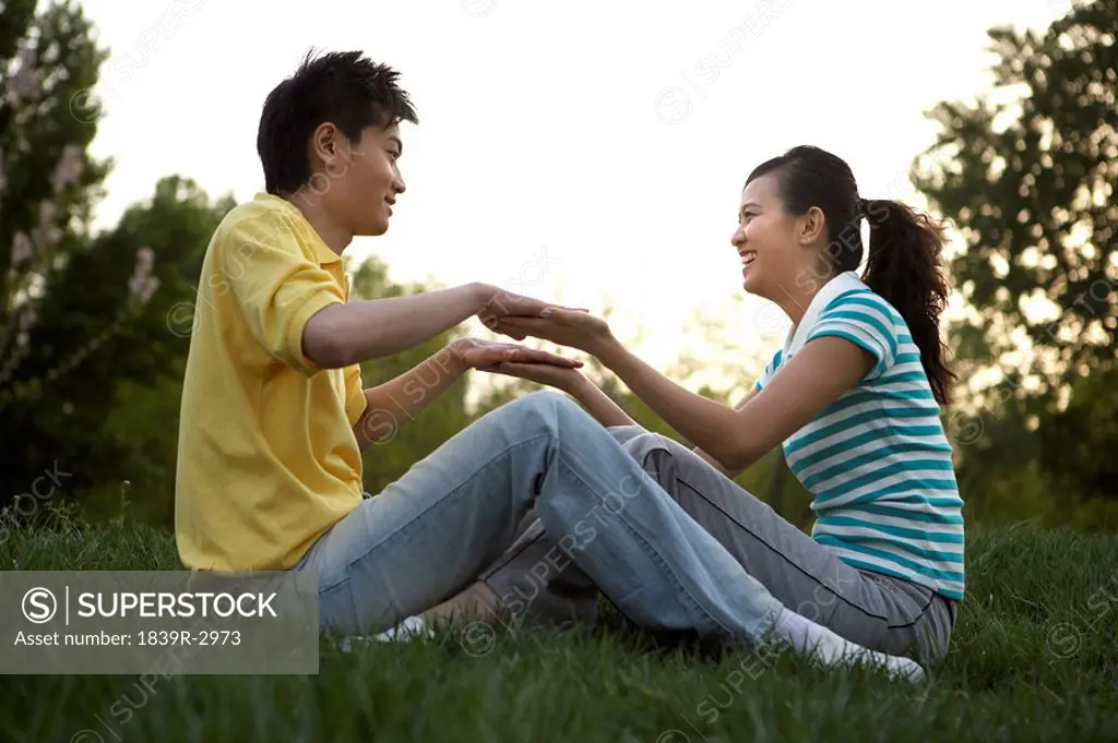 Young Couple Sitting In Park Together