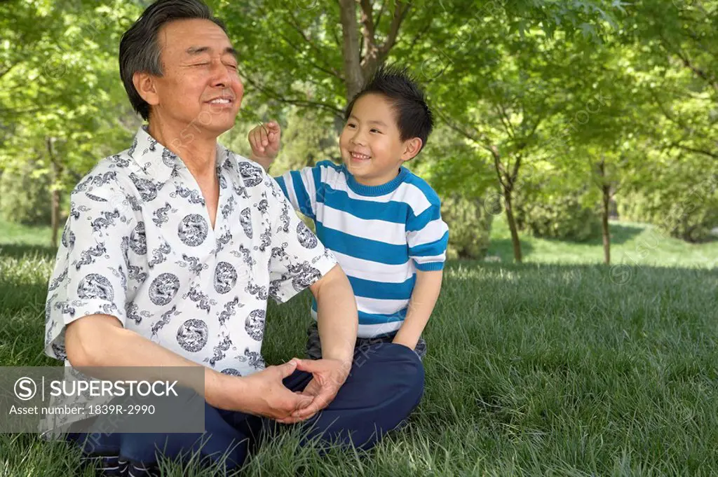 Grandson Annoying Grandfather While He Meditates