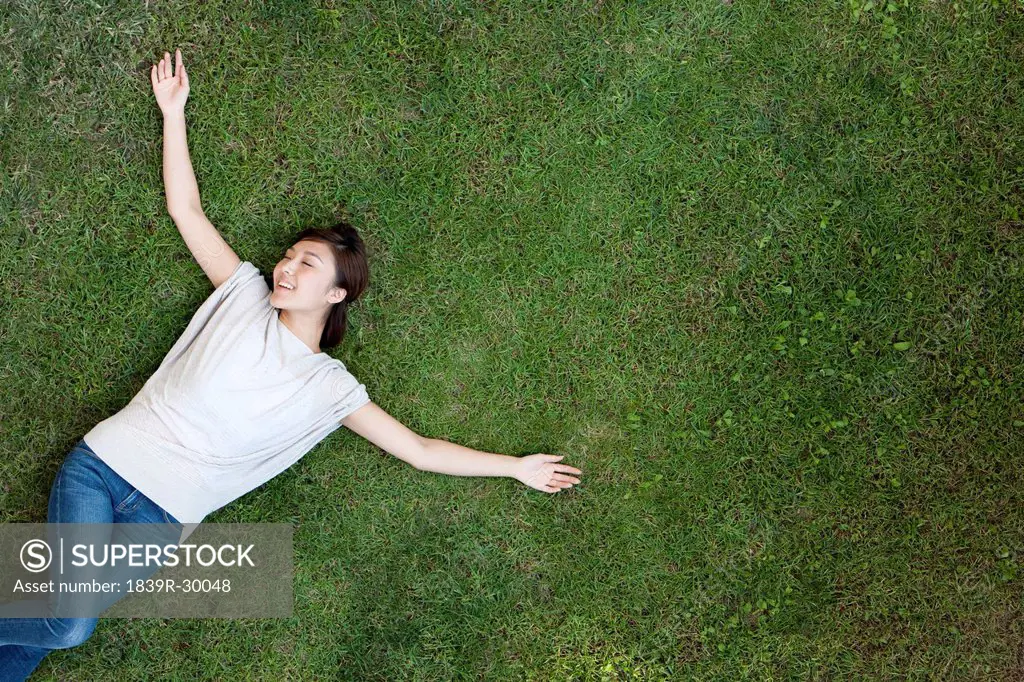 Young Chinese woman lying on the grass