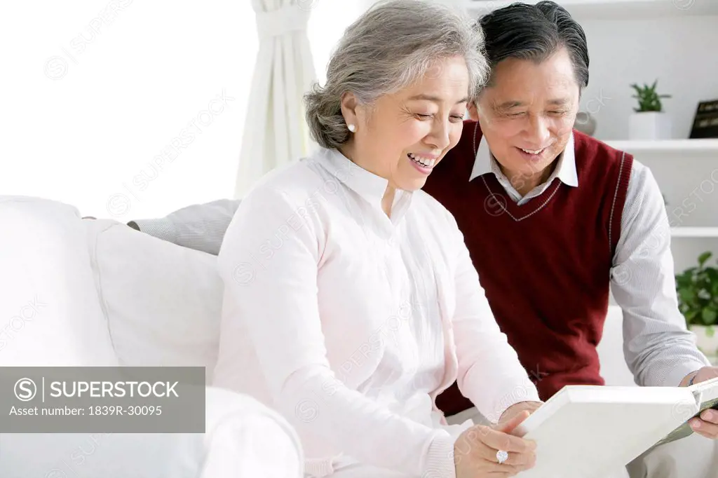 Senior Chinese couple looking at photo album