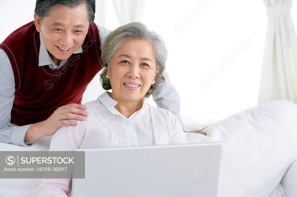 Senior Chinese couple using a laptop
