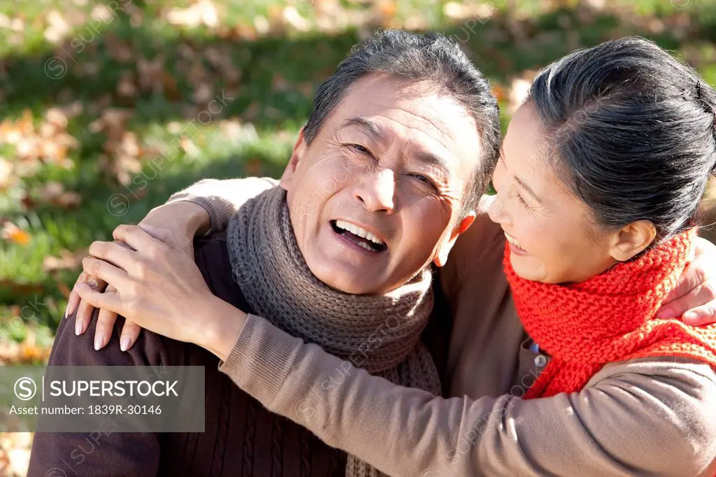 Senior couple embracing in a park in Autumn