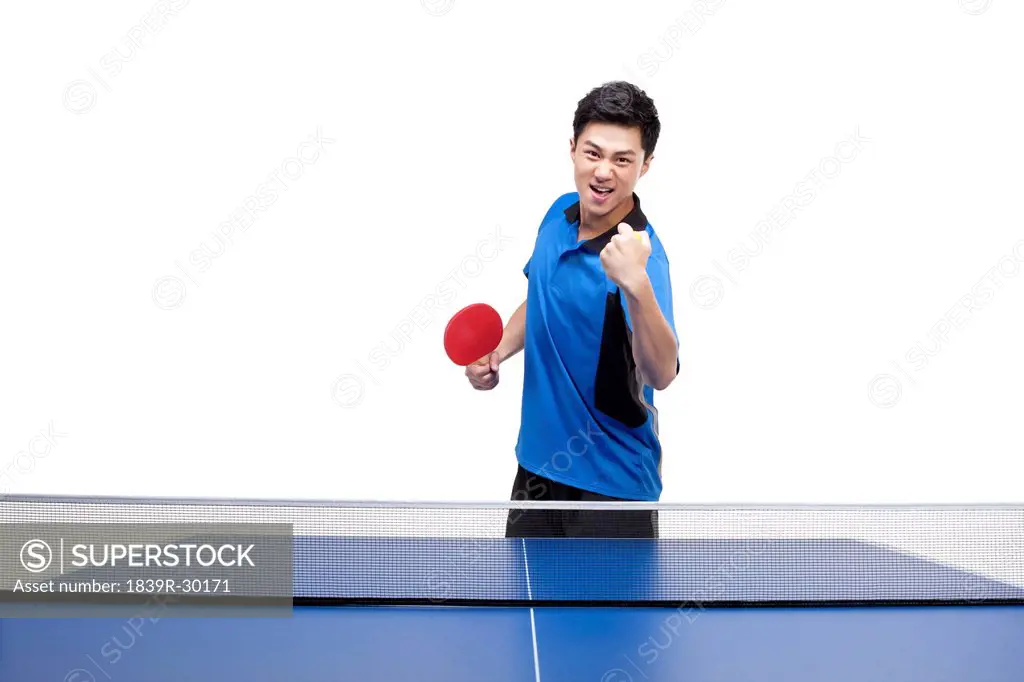 Table tennis player holding up a balled fist