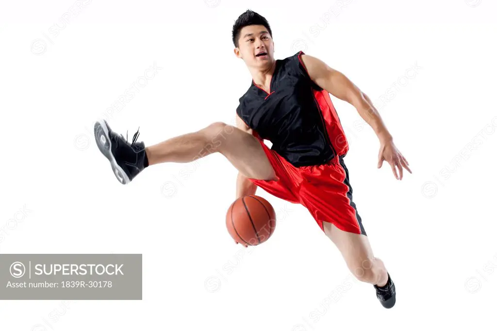 Man jumping doing basketball tricks
