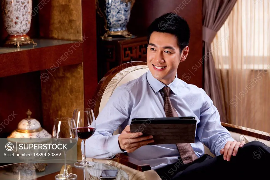 Young businessman using digital tablet in hotel