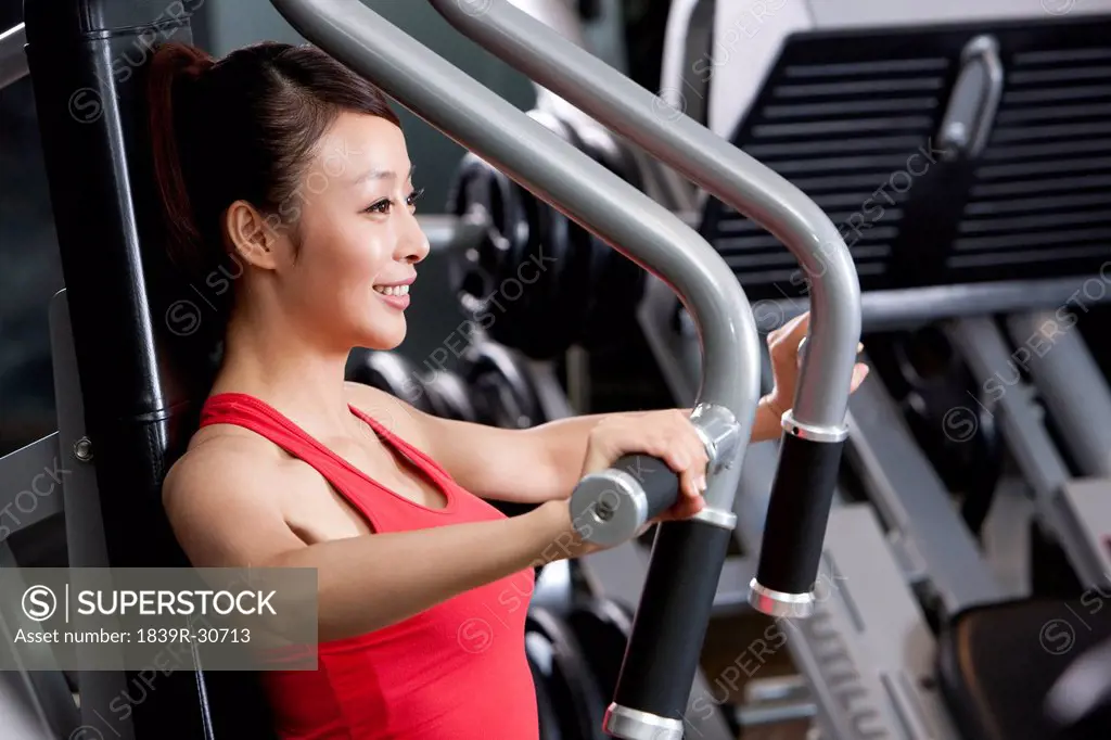 Young Woman Using Exercise Machine