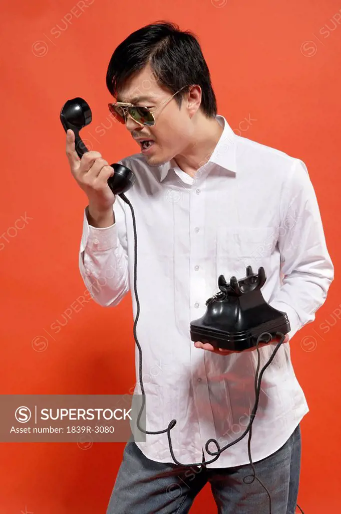 Young Man Yelling At Telephone