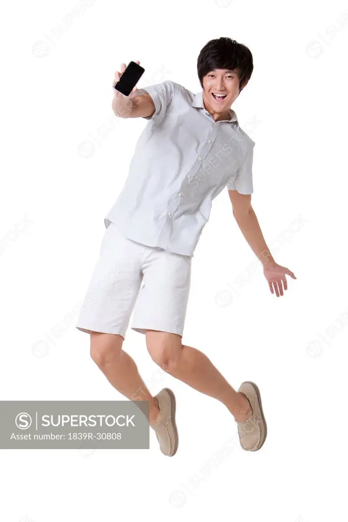Young Man Jumping With a Mobile Phone