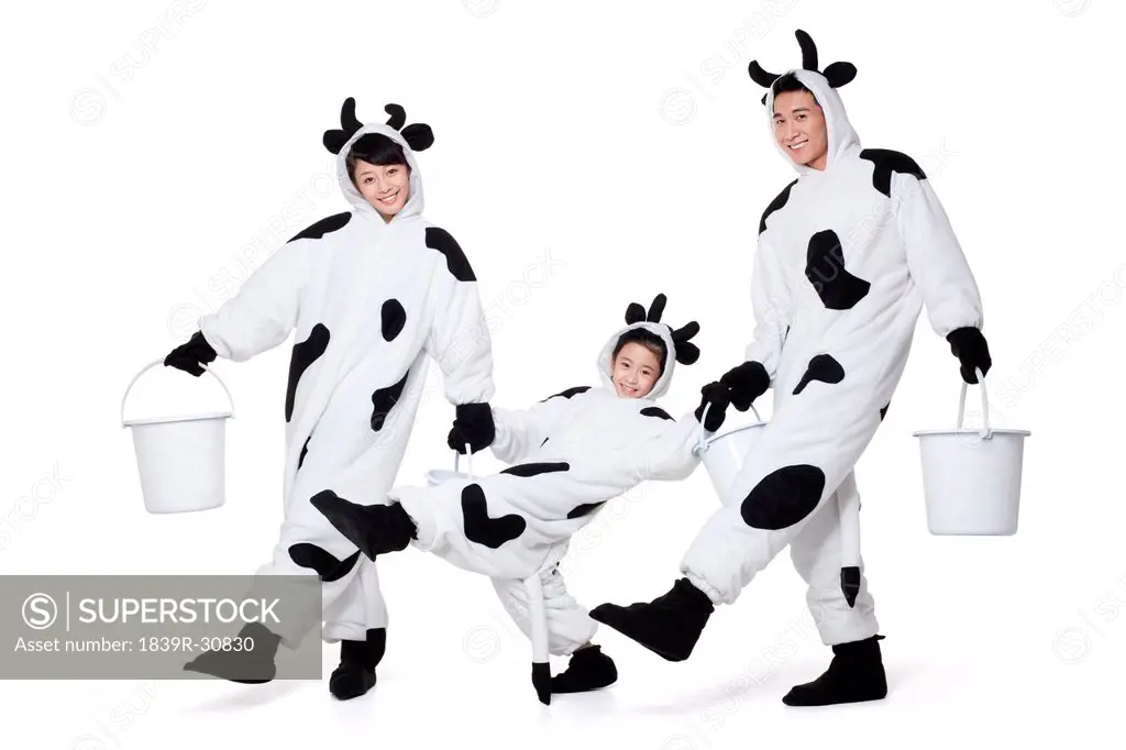 Family in cow costumes playing around with buckets