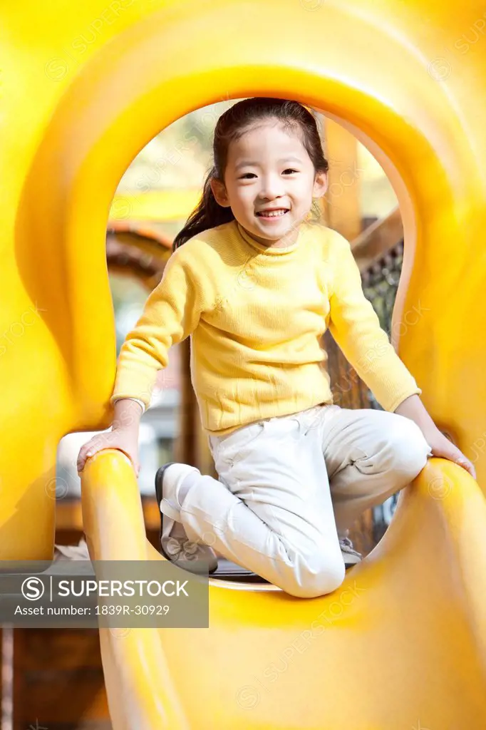 Girl playing on playground slide