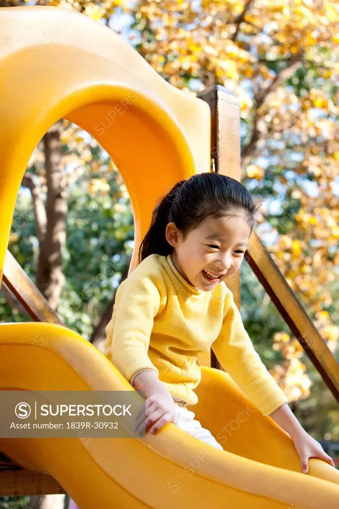 Girl playing on playground slide