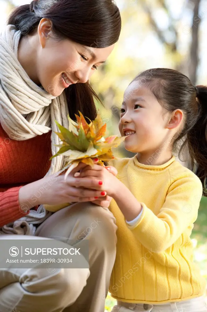 Mother and daughter collecting leaves