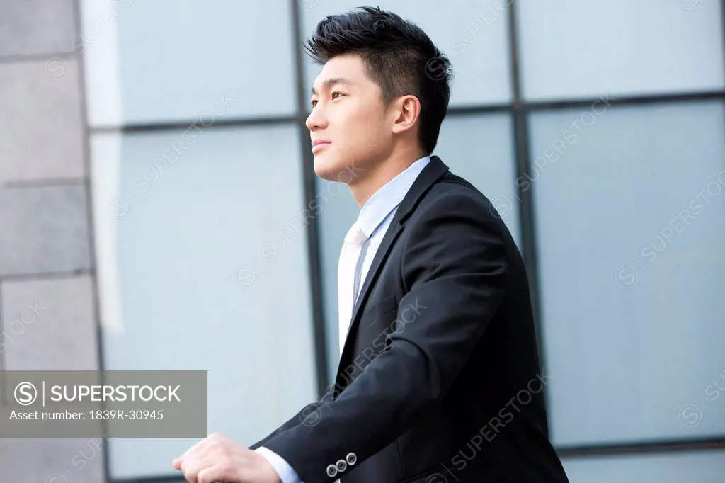 Businessman leaning on a railing deep in thought