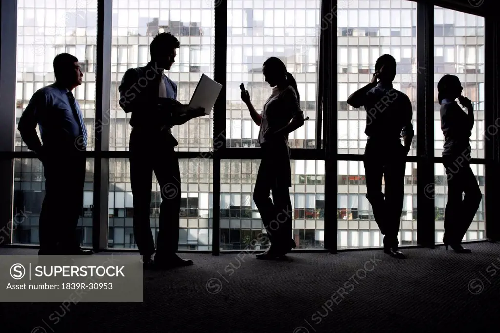 Silhoutte of businesspeople using technology