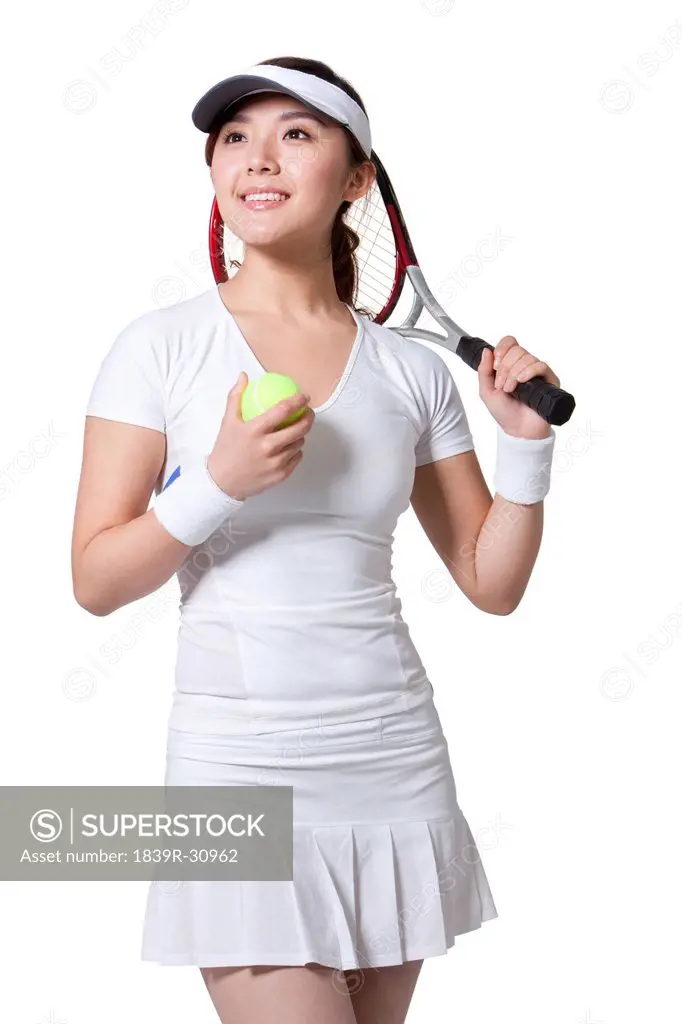 Young woman posing with tennis ball and racket