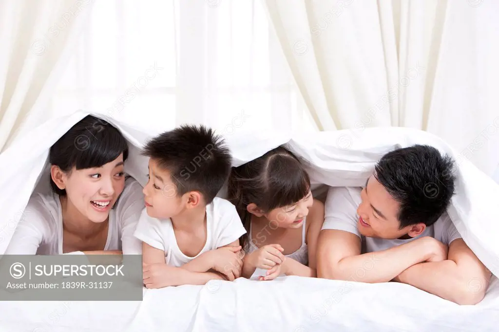 Happy family lying in bed