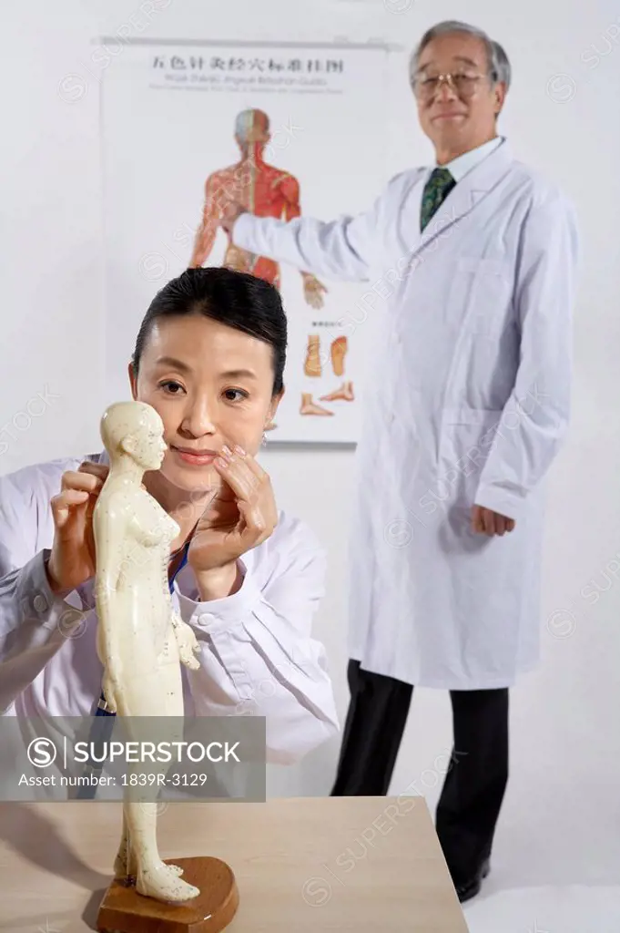 Doctor And Nurse Drawing On Human Acupuncture Figurine