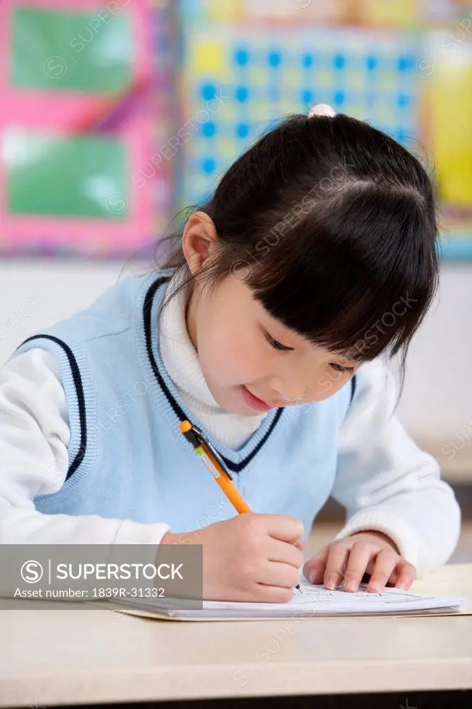 Young student writing in classroom