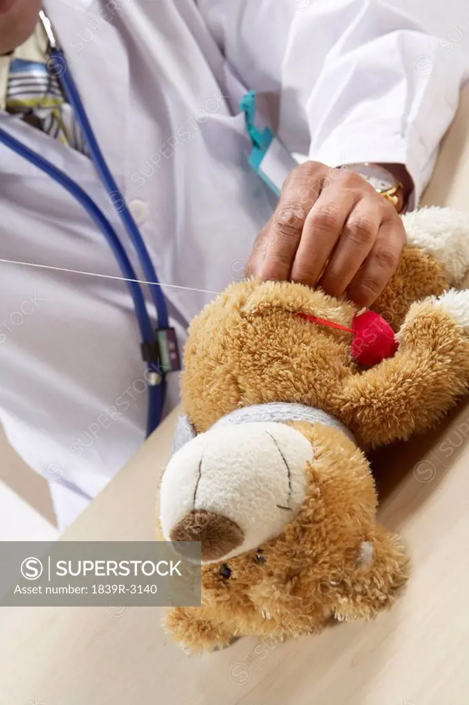 Doctor Listening To A Teddy Bear´s Heart Beat