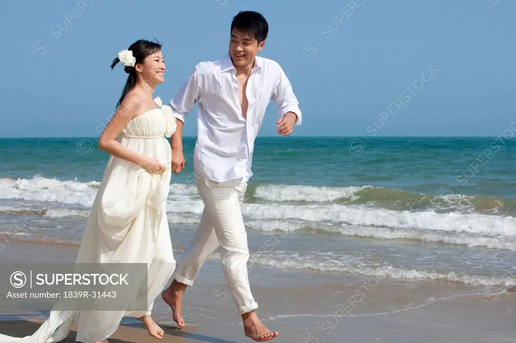 Happy Newlyweds Running on the beach