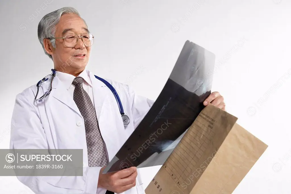 Doctor Looking At X_Ray Sheets