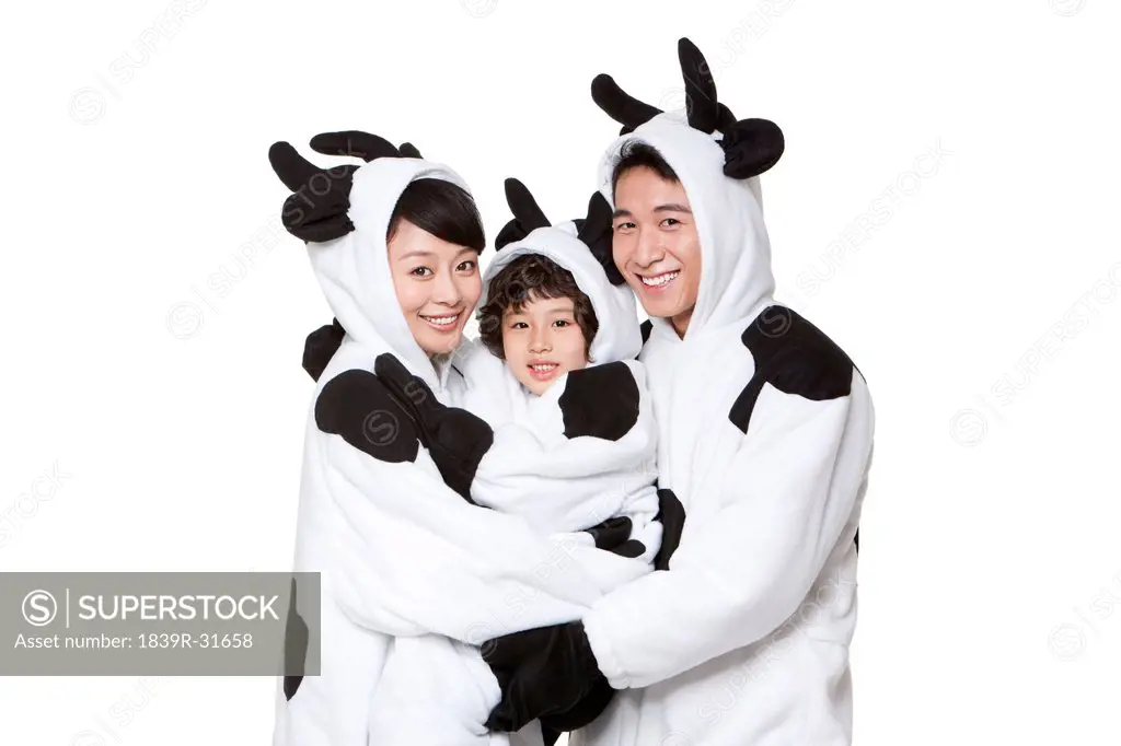 Family in cow costumes embracing each other