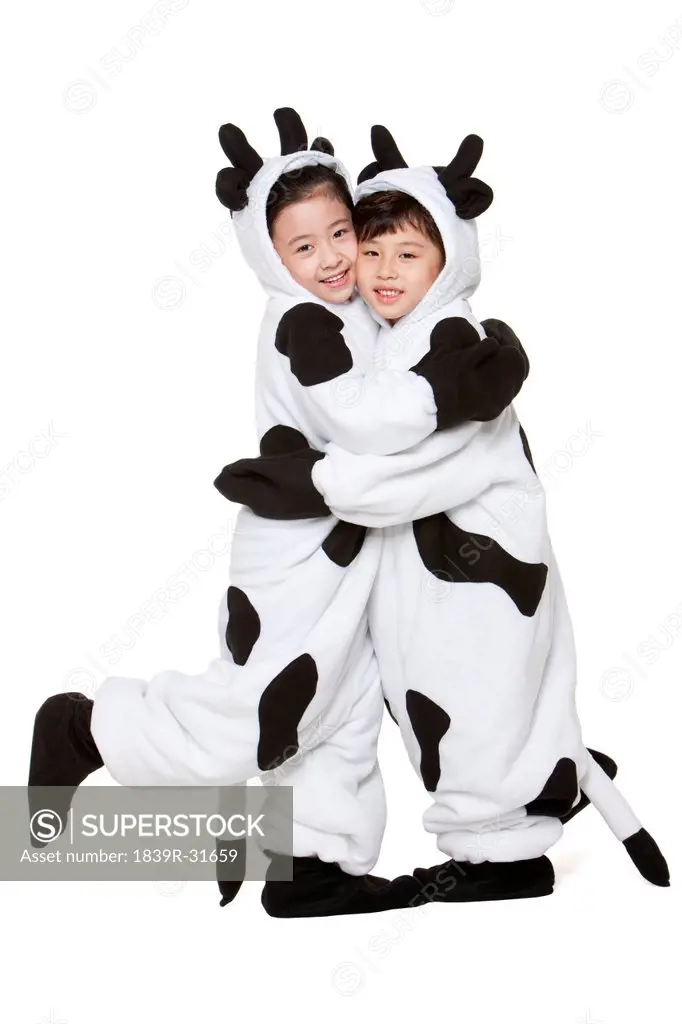 Children in cow costumes hugging each other