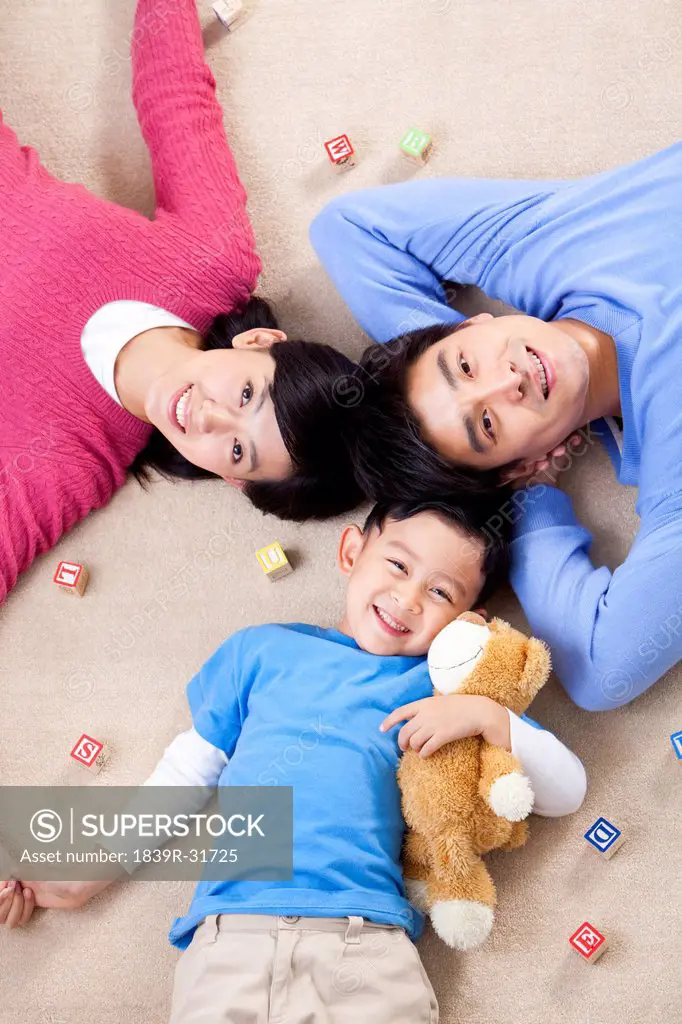 Young Chinese family lying on the floor