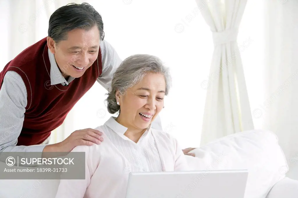 Senior Chinese couple using a laptop