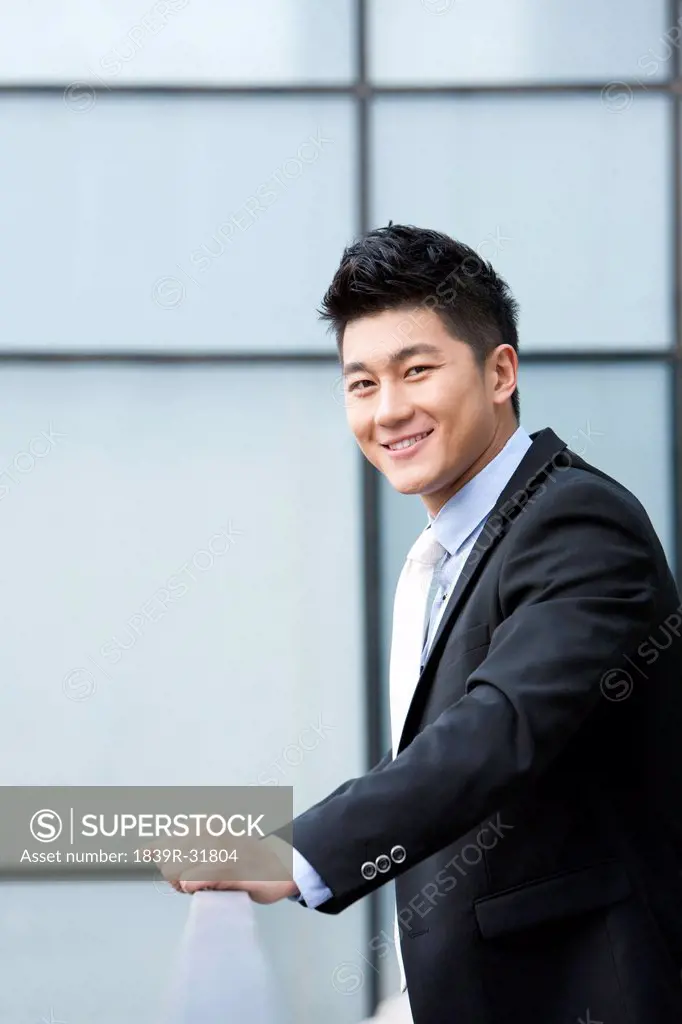 Smiling businessman leaning on the railing