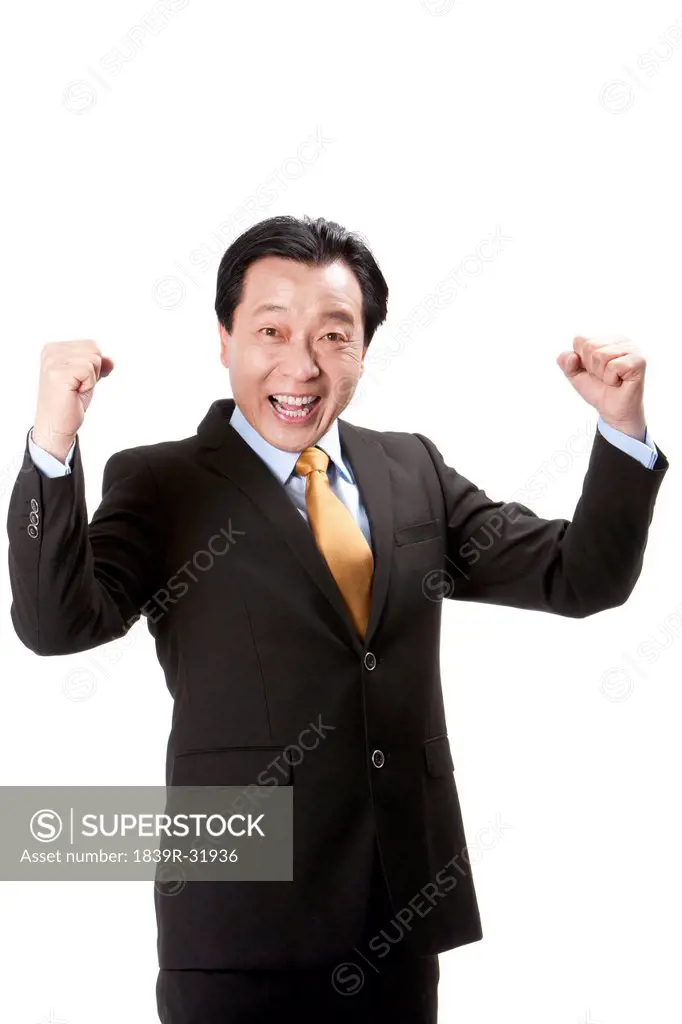 Excited senior businessman punching the air