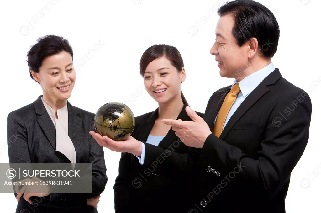 Business team looking at globe