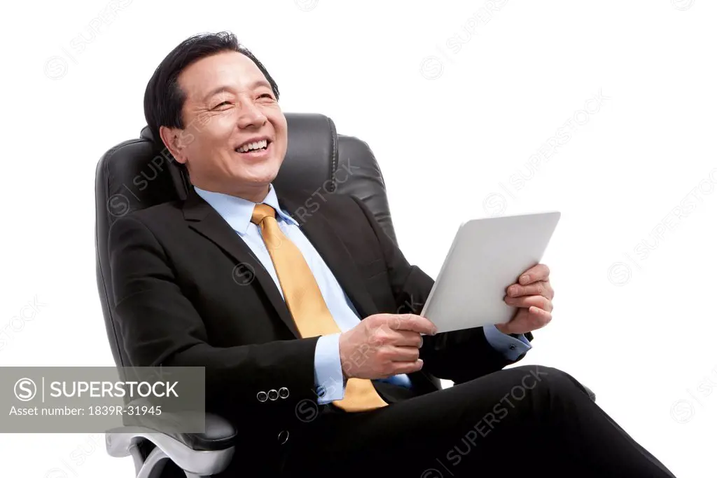 Senior businessman using digital tablet on director´s chair